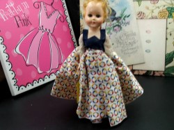 10.5" CIRCA 1950S BLONDE HARD PLASTIC JOINTED DOLL, FULL PRINT SKIRT, VEST, HEART STAND